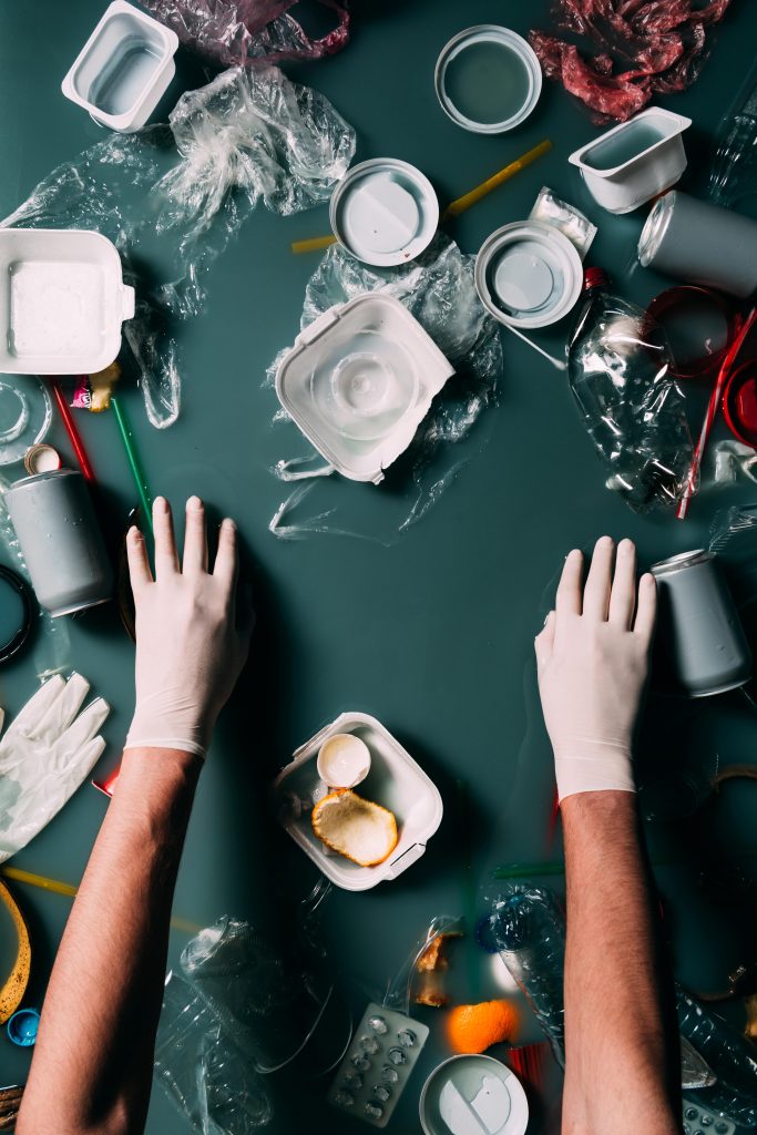 Gloved hands sorting through different garbage and recyclables to avoid contamination