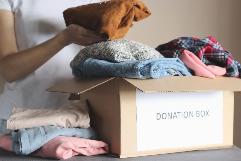 clothes being placed in a donation box