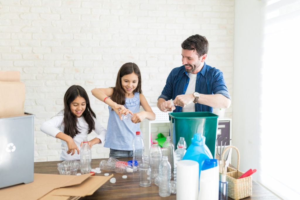 Latin family of three sorting bottles for their recycling program