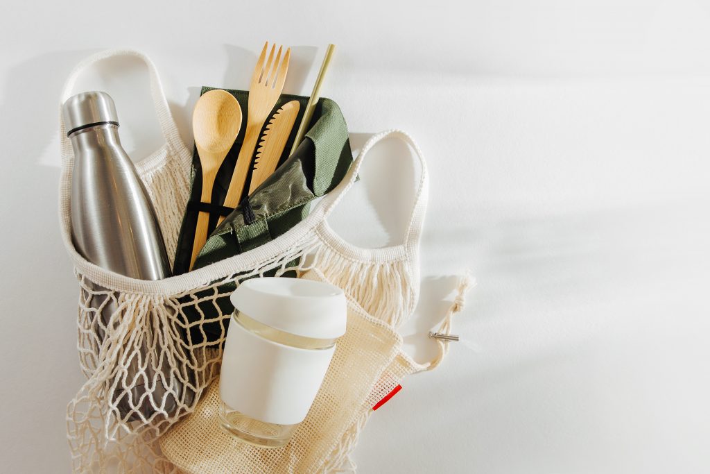 Mesh market bag with bamboo cutlery, reusable coffee mug  and  water bottle. Sustainable lifestyle.  Reduce Plastic Waste concept.