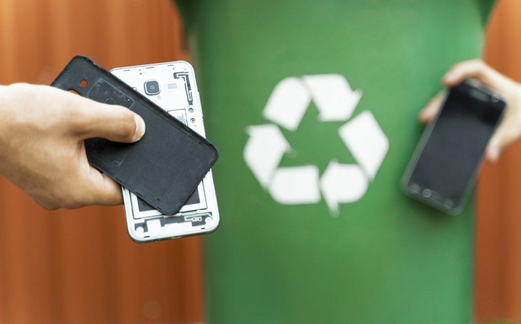 E-waste , recycle old electronics , disassembled smartphone and recycle bin in background