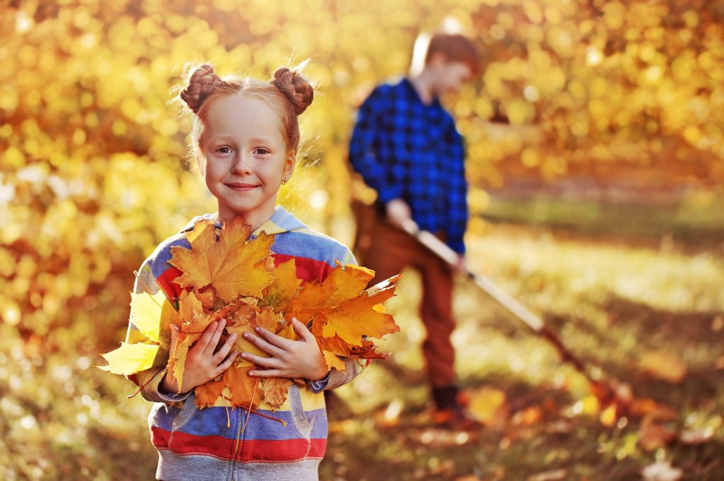 girl holding leaves to add to pumpkin compost