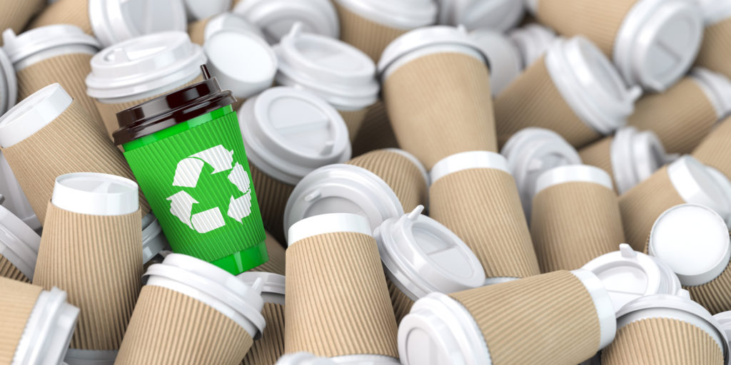 Recycling  sign on one of the heap of many empty paper coffee cups. 3d illustration