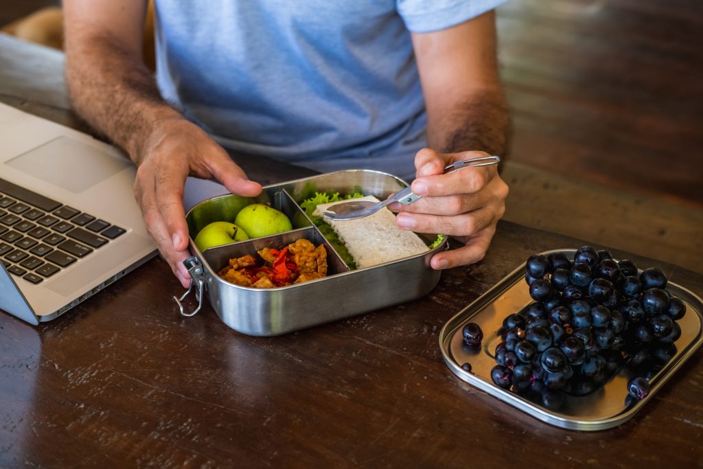 Man eating from a reusable lunch container at work