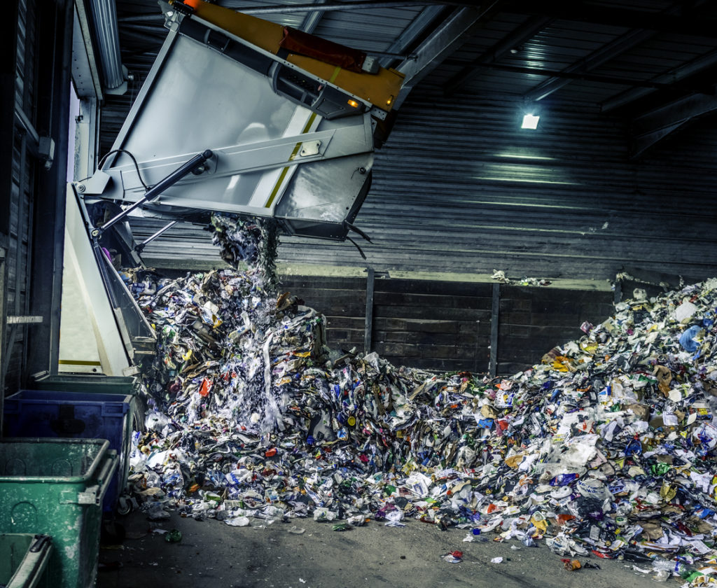 Tipping recycling into a storage shed from a refuse collection lorry. Taken with a slowish shutter speed so some of the recycling has motion blur.