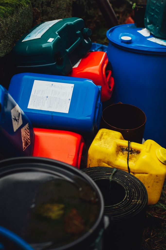 a pile of junk and large containers that may hold hazardous materials which can contaminate recycling