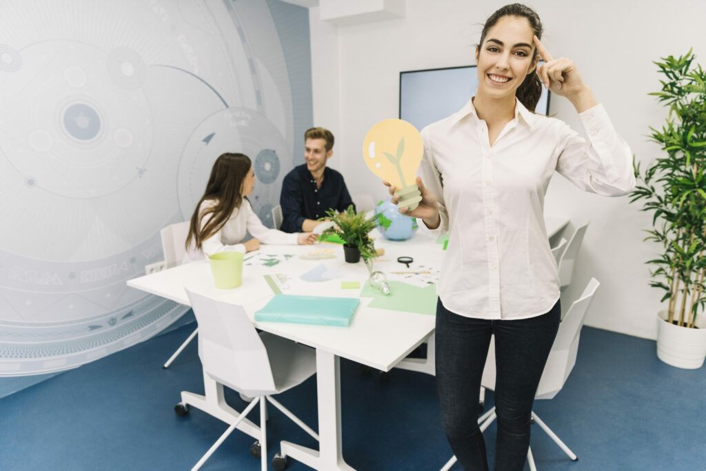 board room meeting with woman holding a lightbulb paper cutout