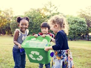 Young school children holding a recycling box