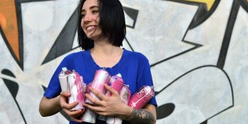 Woman holding aerosol spray paint cans