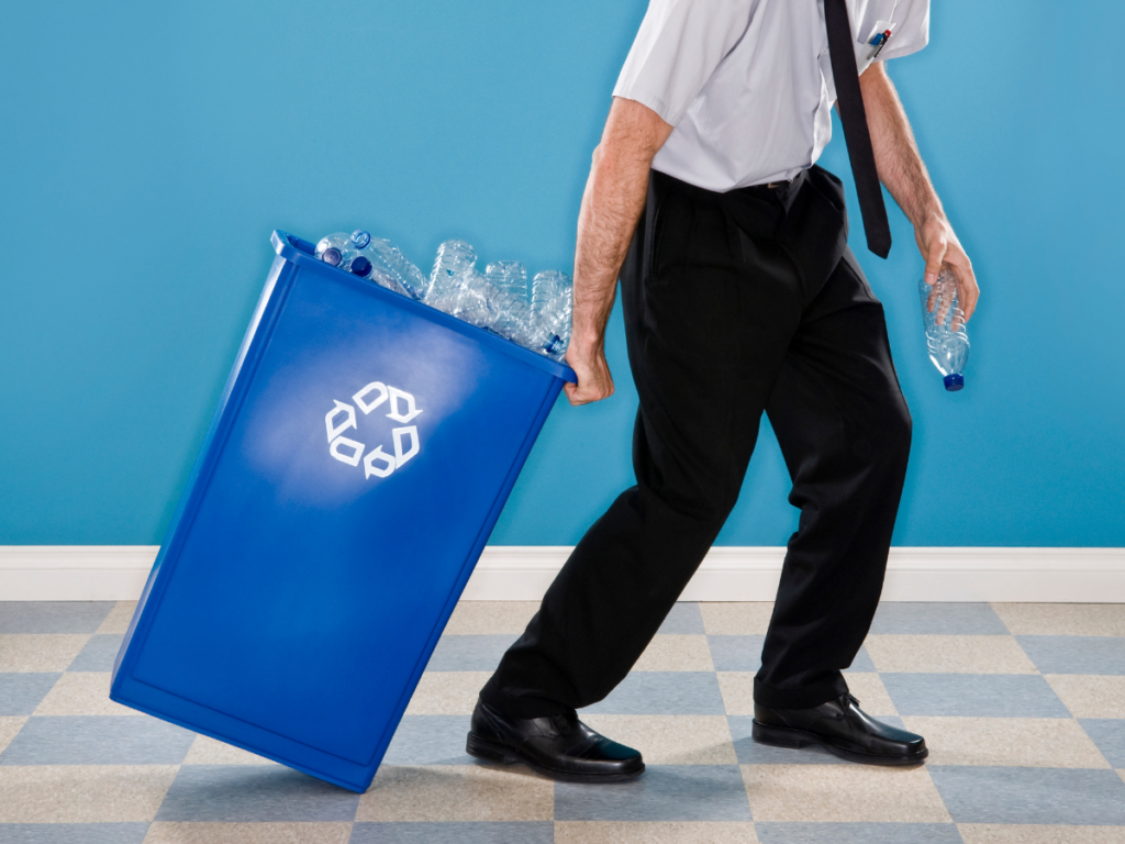 Office worker dragging a recycling bin filled with waterbottles