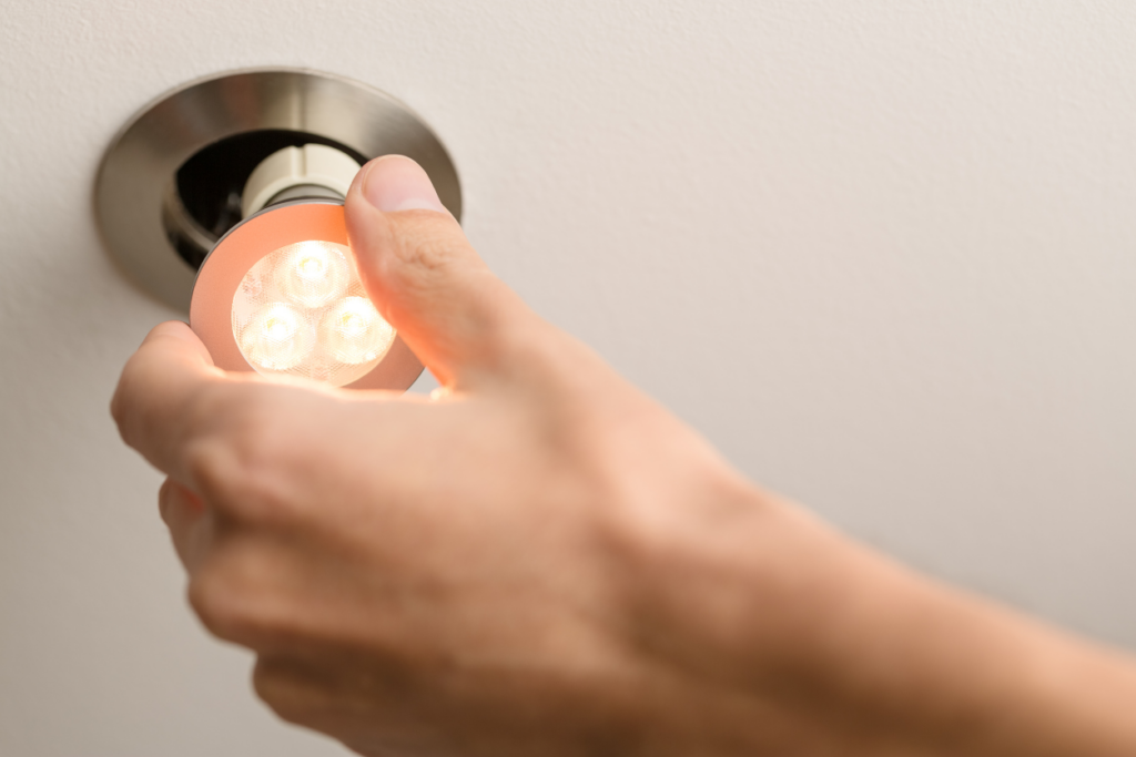 hand putting an LED light into a socket