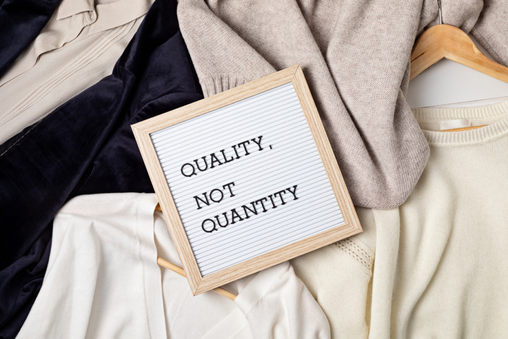 flat lay of women's clothes with text board that says quality, not quantity