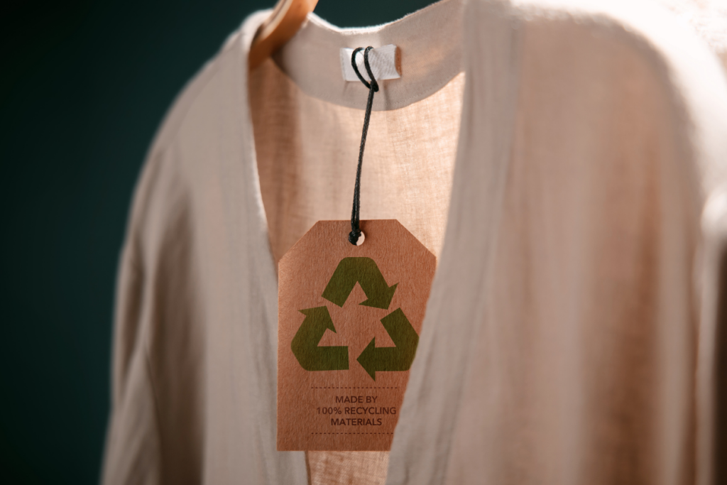 Shirt on hanger with tag that says made from recycled materials