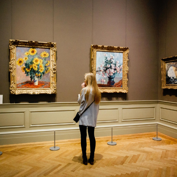 woman looking at paintings in an art museum