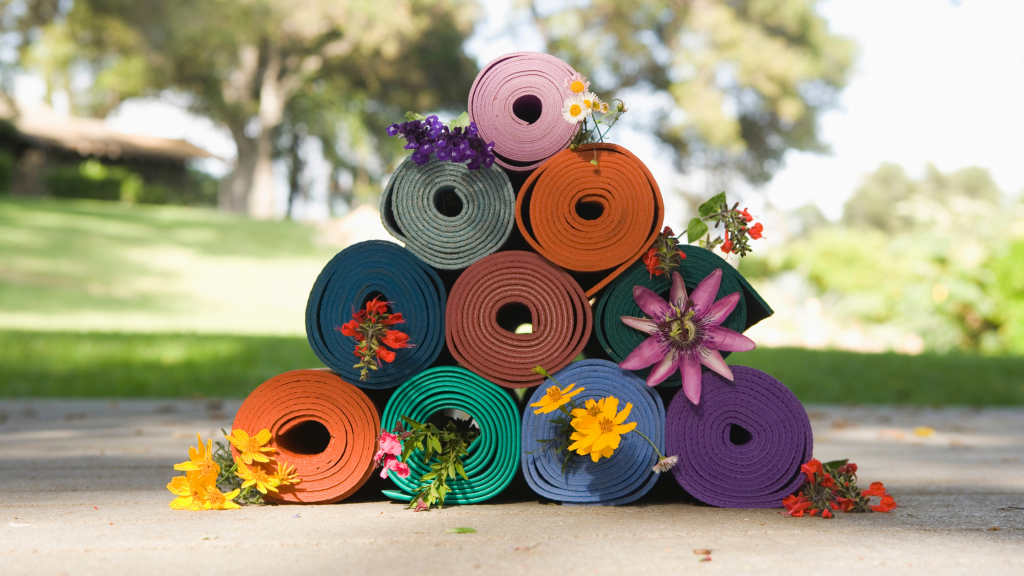 Pyramid pile of old yoga mats with flowers in them