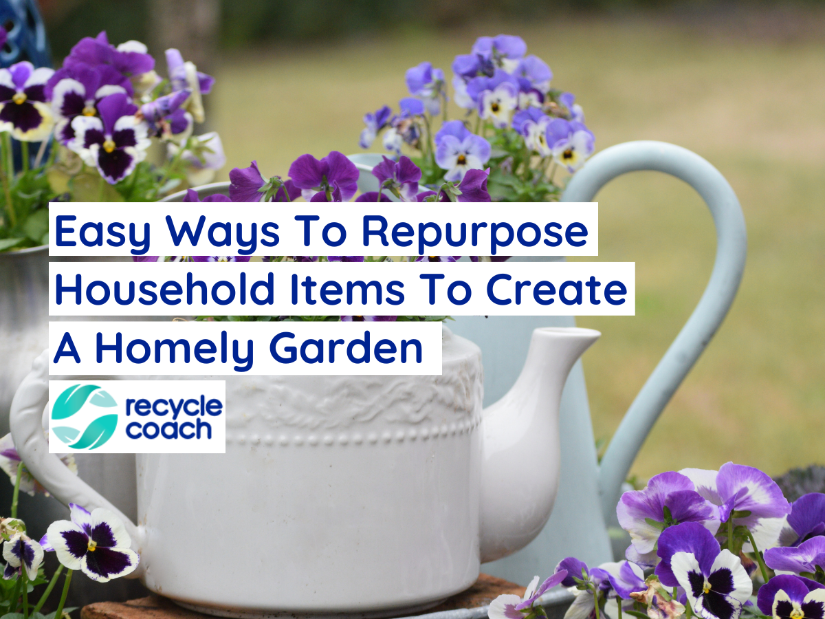 Blooming pansy and viola plants in old fashion teapot and metal pitchers